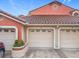 Charming condo featuring multi-car garage with neutral tone doors, orange-colored stucco, and Spanish tile roofing at 7865 Sugar View Ct # 7865, Orlando, FL 32819