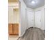 Hallway with wood floors, multiple doors, and a view into a bathroom with a wood vanity at 7865 Sugar View Ct # 7865, Orlando, FL 32819