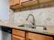 Close-up on the kitchen sink with granite countertops, stainless steel appliances, and wood cabinets at 7865 Sugar View Ct # 7865, Orlando, FL 32819