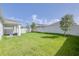 A spacious backyard features green grass, a privacy fence, and a covered patio at 824 Ofanto Way, Haines City, FL 33844