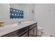 Bathroom features a white countertop, dark wood cabinets, large mirror, and bathtub/shower with blue flower curtain at 824 Ofanto Way, Haines City, FL 33844
