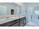 Bathroom boasts double sinks, sleek cabinets, glass shower, and tile floors at 824 Ofanto Way, Haines City, FL 33844