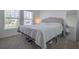 Comfortable bedroom featuring soft carpet, large windows, and a stylish headboard with a full-length mirror at 824 Ofanto Way, Haines City, FL 33844