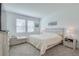 A bedroom with large windows, a bed with a white comforter, and neutral colored furniture at 824 Ofanto Way, Haines City, FL 33844