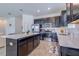 Modern kitchen features sleek cabinets, stainless steel appliances, tile flooring, and quartz countertops at 824 Ofanto Way, Haines City, FL 33844