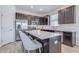 Modern kitchen boasts stainless steel appliances, dark cabinets, quartz countertops, and a central island with seating at 824 Ofanto Way, Haines City, FL 33844