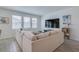 Bright living room featuring a large sectional sofa, wood floors, and large windows providing ample natural light at 824 Ofanto Way, Haines City, FL 33844