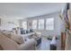 Bright living room featuring a large sectional sofa, wood floors, and large windows providing ample natural light at 824 Ofanto Way, Haines City, FL 33844