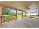 Covered back porch features a ceiling fan, concrete flooring, and a scenic view of the fenced backyard and pond at 8322 Cascade Oaks Dr, Orlando, FL 32822