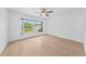 Bright bedroom with large window offering outdoor views and light wood-look floors at 8322 Cascade Oaks Dr, Orlando, FL 32822