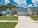 Charming one-story blue home with a two-car garage and manicured front yard at 8322 Cascade Oaks Dr, Orlando, FL 32822