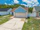 Charming one-story blue home with a two-car garage and manicured front yard at 8322 Cascade Oaks Dr, Orlando, FL 32822