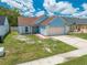 Charming one-story blue home with a two-car garage and manicured front yard at 8322 Cascade Oaks Dr, Orlando, FL 32822