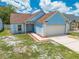 Charming one-story blue home with a two-car garage and manicured front yard at 8322 Cascade Oaks Dr, Orlando, FL 32822