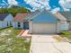 Charming one-story blue home with a two-car garage and manicured front yard at 8322 Cascade Oaks Dr, Orlando, FL 32822