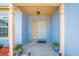 Inviting front porch with plants in decorative pots and a white front door at 8322 Cascade Oaks Dr, Orlando, FL 32822