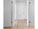Hallway featuring neutral tile flooring connecting multiple rooms in the home at 8322 Cascade Oaks Dr, Orlando, FL 32822