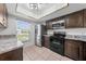 Well-lit kitchen with stainless steel appliances, granite countertops, and dark wood cabinets at 8322 Cascade Oaks Dr, Orlando, FL 32822