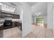 Modern kitchen with dark cabinets, stainless steel appliances, and a view to the living room at 8322 Cascade Oaks Dr, Orlando, FL 32822