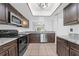 Contemporary kitchen with stainless steel appliances, dark wood cabinets, granite countertops, and eat-in bar at 8322 Cascade Oaks Dr, Orlando, FL 32822