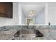 Granite countertop with stainless steel sink overlooking a dining area with modern chandelier at 8322 Cascade Oaks Dr, Orlando, FL 32822
