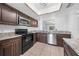 Fully equipped kitchen featuring dark wood cabinets, stainless steel appliances and eat-in bar at 8322 Cascade Oaks Dr, Orlando, FL 32822