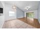 Open living room with wood flooring, a ceiling fan, and access to a patio at 8322 Cascade Oaks Dr, Orlando, FL 32822