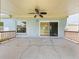 Covered outdoor patio with ceiling fan, concrete flooring, and access to the backyard through sliding glass doors at 8322 Cascade Oaks Dr, Orlando, FL 32822