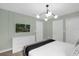 Light and airy bedroom offers a dresser with television and en-suite bathroom at 9020 Stinger Dr, Davenport, FL 33896