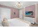 Cozy bedroom boasting modern lighting, pastel accents, and a sleek dresser with TV at 9020 Stinger Dr, Davenport, FL 33896