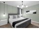 Modern bedroom with a minimalist design, stylish light fixture, and soothing green walls at 9020 Stinger Dr, Davenport, FL 33896