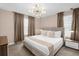 Relaxing bedroom features a king-size bed, stylish chandelier, and neutral tones at 9020 Stinger Dr, Davenport, FL 33896