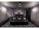 Elegant home theater with black leather seating, custom lighting, and a projection screen at 9020 Stinger Dr, Davenport, FL 33896