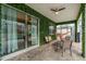 Outdoor lanai with brick floors, patio furniture, mounted T-Rex statue and lush green walls at 9020 Stinger Dr, Davenport, FL 33896