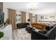 Open-concept living room featuring modern sofas, stylish decor, and an elegant chandelier at 9020 Stinger Dr, Davenport, FL 33896