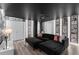 Charming living room with black sectional sofa, movie-themed decor, and light wood flooring at 9020 Stinger Dr, Davenport, FL 33896