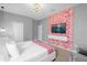 Stylish main bedroom featuring a modern TV on a pink flower accent wall and contemporary chandelier at 9020 Stinger Dr, Davenport, FL 33896