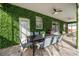 Inviting outdoor patio with dining table, ceiling fans, and a lush green privacy wall at 9020 Stinger Dr, Davenport, FL 33896