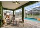 Screened-in patio with a pool view, outdoor seating, dinosaur decor, and well-maintained stone pavers at 9020 Stinger Dr, Davenport, FL 33896