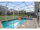 Sparkling screened-in pool and spa area with outdoor lounge chairs and lush landscaping at 9020 Stinger Dr, Davenport, FL 33896