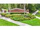 Beautifully landscaped entrance to Indian Lakes neighborhood with colorful plants and lush greenery at 952 Chamberlin Trl, St Cloud, FL 34772
