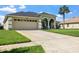 Front exterior view of home with spacious driveway and manicured front lawn and mature landscaping at 952 Chamberlin Trl, St Cloud, FL 34772