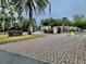 Stone signage marks entrance to Hawthorne Village surrounded by palm trees and meticulous landscaping along brick paved drive at 9916 Sweepstakes Ln # 7, Orlando, FL 32837