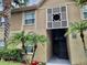 Condo exterior with palm trees, brick accents, a stairwell, and decorative white latticework above the entrance at 9916 Sweepstakes Ln # 7, Orlando, FL 32837