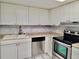 Well-lit kitchen showcases ample cabinet space, stainless steel dishwasher and oven against marble style backsplash at 9916 Sweepstakes Ln # 7, Orlando, FL 32837