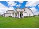 Exterior view of a home's backyard with lush green grass and a covered patio at 10364 Shive Island Ct, Orlando, FL 32827