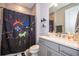 Charming bathroom with a splash-themed shower curtain, gray cabinetry and chrome faucet at 10364 Shive Island Ct, Orlando, FL 32827