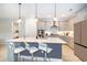 Well-lit kitchen with an island that seats three, stainless appliances, and modern cabinetry at 10364 Shive Island Ct, Orlando, FL 32827
