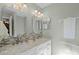 Bright bathroom with a double sink vanity, marble countertops, and modern fixtures at 11730 Kennington Ct, Orlando, FL 32824