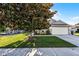 Well-maintained home featuring a lush green lawn, mature tree, and a two-car garage at 11730 Kennington Ct, Orlando, FL 32824